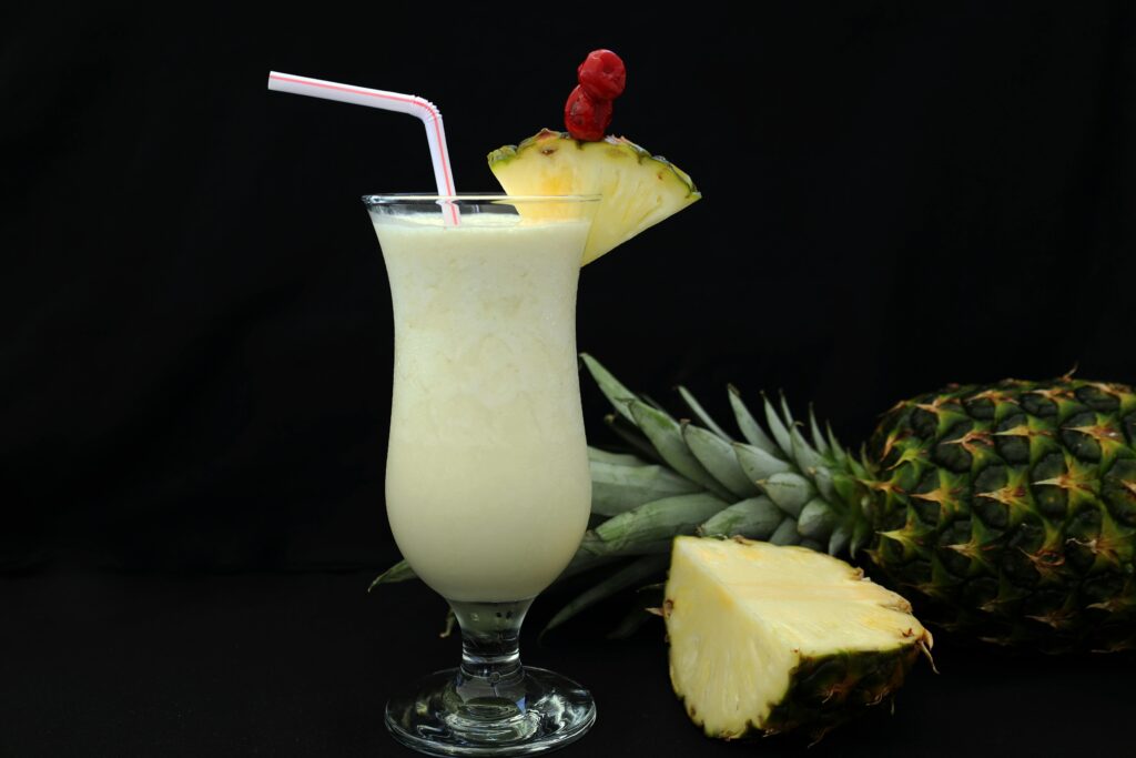 Close-up of a pina colada with pineapple garnish and straw, perfect for a tropical vibe.